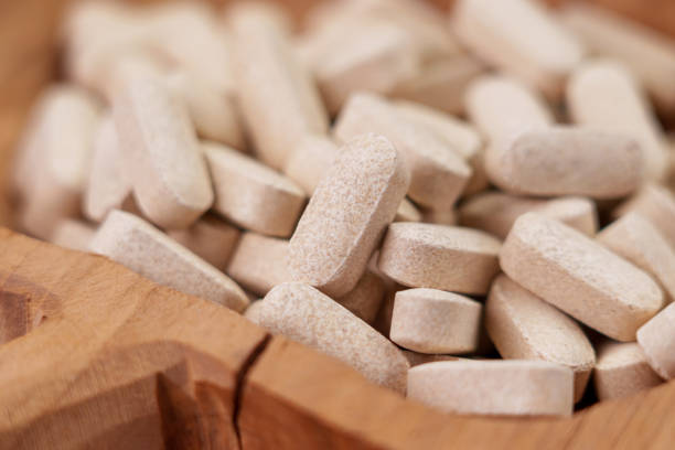 istock Vitamin nutritional supplement pills in cracked wooden rustic container 1441391850
