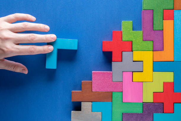 istock Concept of decision making process. Logical tasks. Hand holding wooden puzzle element. Hand sets the element of the puzzle. 1441392532