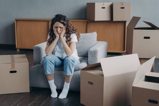istock Exhausted upset woman sitting with cardboard boxes on relocation day. Financial problem, eviction 1441395617
