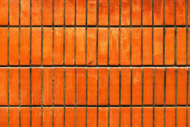 Dirty orange brick wall as urban texture and background with stain marks
