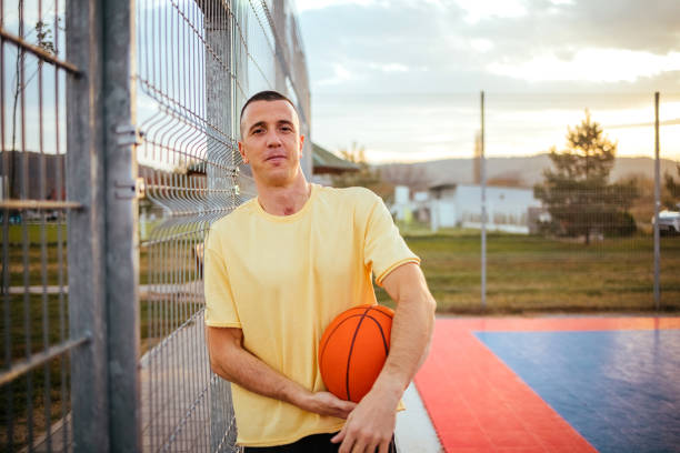 Portrait of a young man holding a basketball in his hands