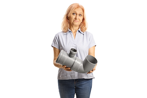 Confused woman holding a plastic water pipe isolated on white background