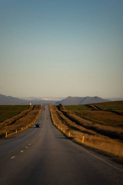 Long open road in Iceland with a single car on the road