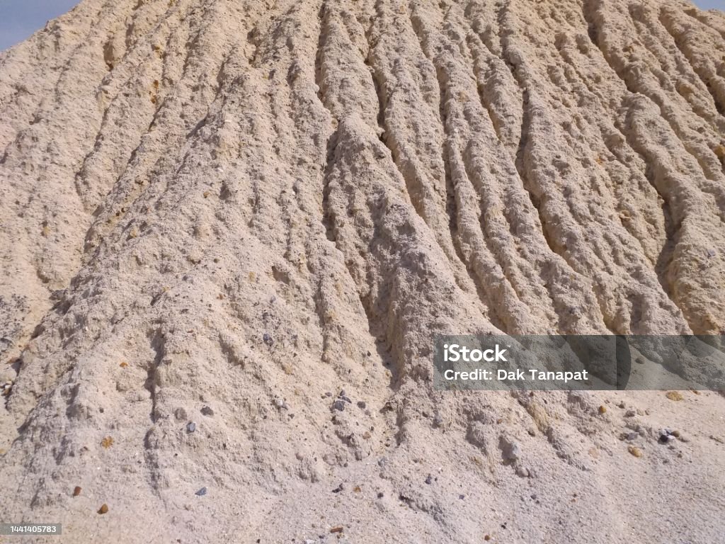 Surface of sand pile washed by rain drops Groove on the surface of sand pile washed by rain drops Color Image Stock Photo