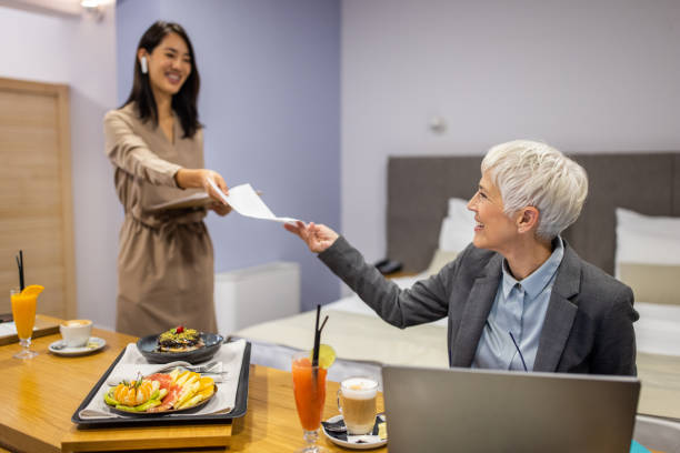 empresária fazendo o trabalho enquanto trabalha na suíte do hotel com seu assistente pessoal - room service audio - fotografias e filmes do acervo