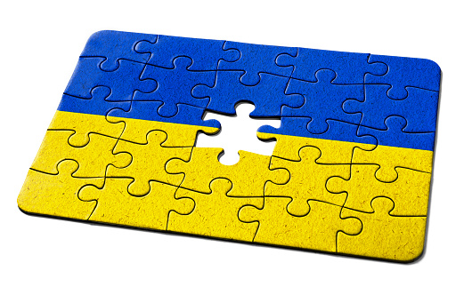 Ukrainian national flag printed on a jigsaw puzzle with lots of texture, representing a government or political problem to be solved.