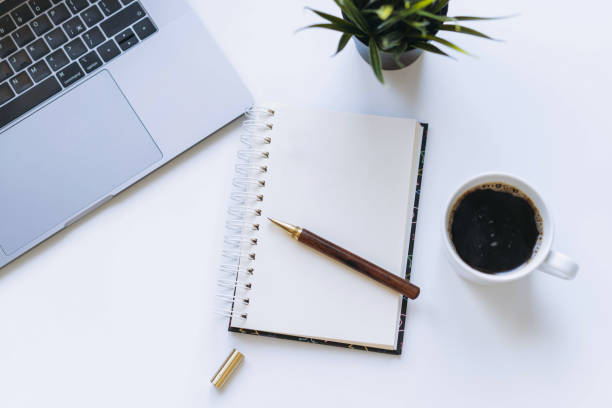 istock open notepad with blank sheet. Flower, laptop and coffee cup on background. 1441408843