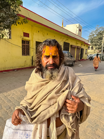 Pushkar, Rajasthan, India - November 2022: Portrait of an old  sadhu on the street of pushkar in traditional dress. Sadhu in pushkar fair comes to have holy dip in lake.