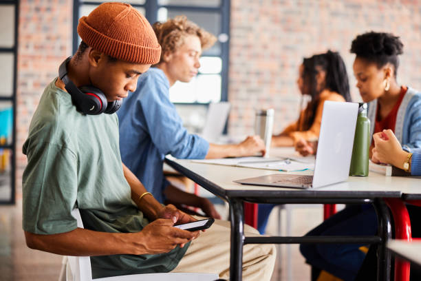 istock Young male student checking his phone during a class 1441411387