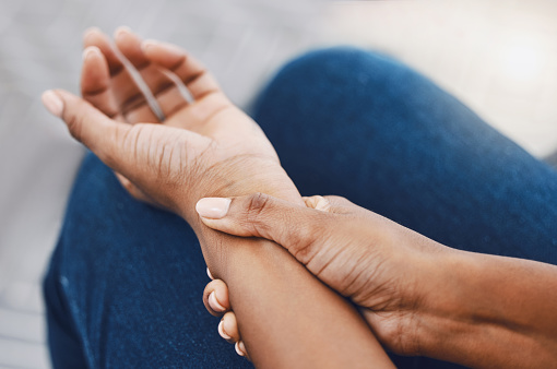 Hands, arm injury or pain of black woman after working hard in home or house interior. Hand, health and wellness of African female injured wrist after work on pc computer, carpal tunnel or arthritis.