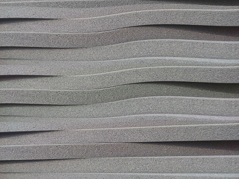 stacks or arrangements of thin grey foam sheet material arranged transversely. sponge foam background