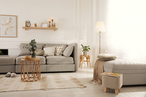 istock Living room with comfortable grey sofa, ottoman and stylish interior elements near window 1441416089