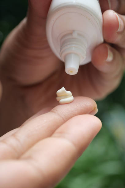 istock person hand using sunscreen cream outdoor 1441416211