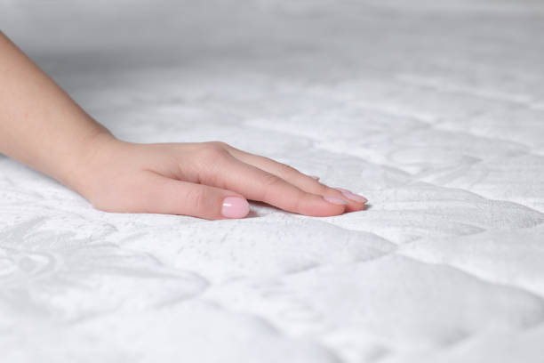 istock Woman touching soft white mattress, closeup view 1441416307