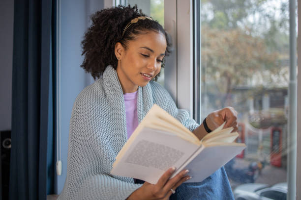 istock Woman relaxing and reading a book 1441416639