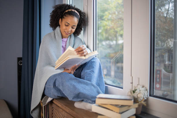 istock Happy woman reading book at home 1441416643