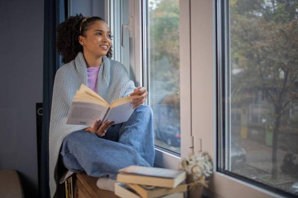 istock Happy woman reading book at home 1441416869