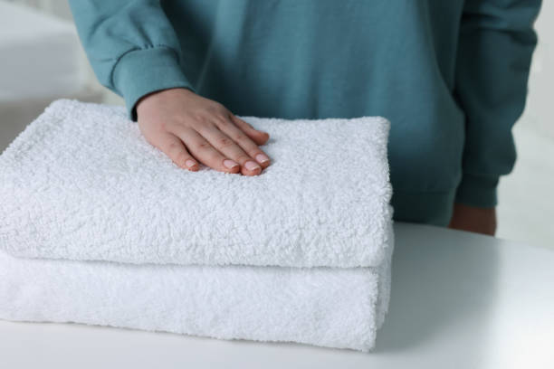 istock Woman touching soft white towel indoors, closeup 1441416933