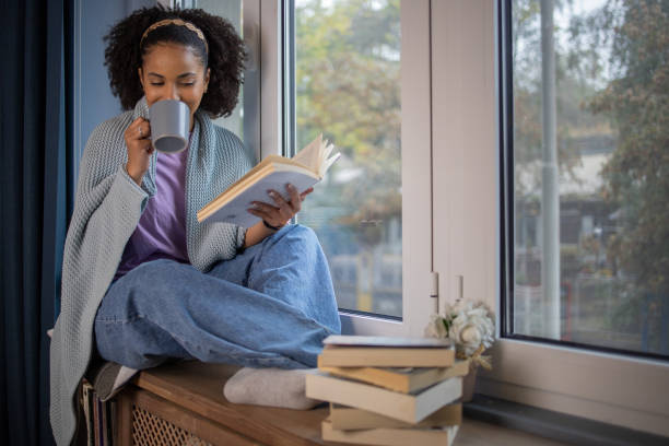 istock Woman relaxing and reading a book 1441417567