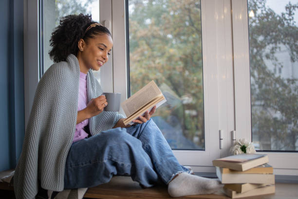 istock Woman relaxing and reading a book 1441417632