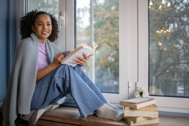 istock Happy woman reading book at home 1441417683