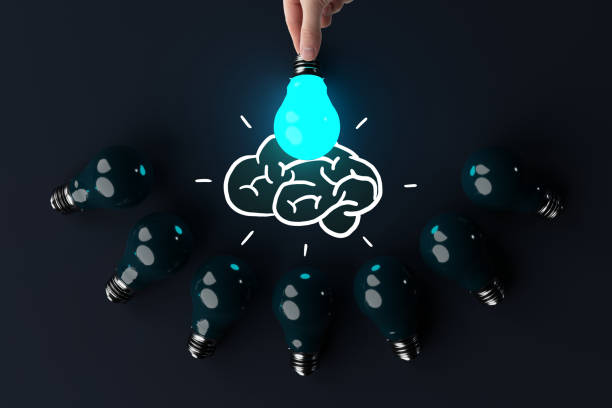 istock A hand holds a lit light bulb against the background of other extinguished light bulbs and a sketch of the brain. 1441417709