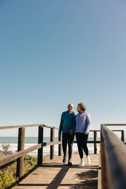 istock Romantic senior couple taking a walk on a boardwalk at the beach 1441417715