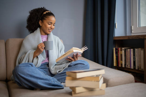 istock Happy woman reading book at home 1441417740