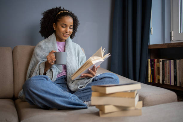 istock Woman relaxing and reading a book 1441417744