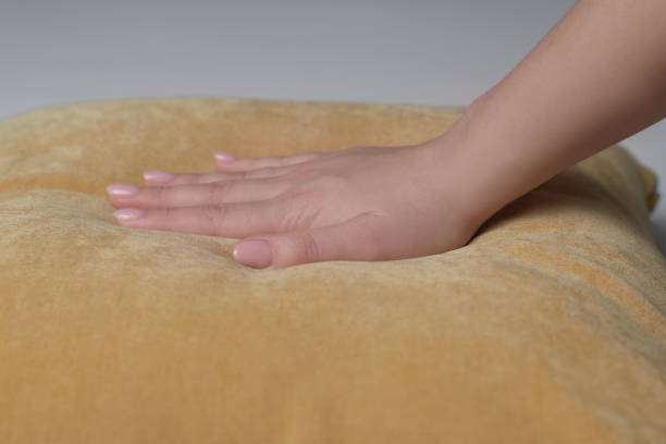 istock Woman touching soft yellow pillow on bed, closeup 1441417757