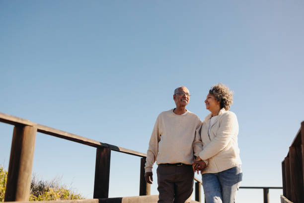 istock Romantic senior couple taking a walk together at the beach 1441417812