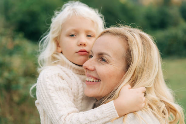 istock Little blond girl hugging her mom 1441418079