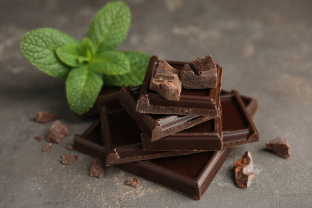 istock Tasty dark chocolate pieces with mint on grey table 1441418298