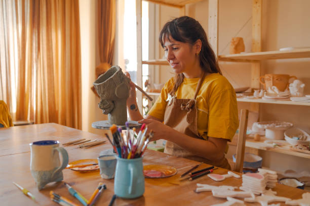 istock Young woman making pottery vase with clay in her workshop 1441418400
