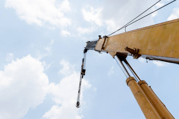 istock Yellow crane boom with hooks and blue sky background 1441418467
