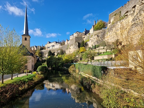 Reflection of church spire tower along riverside walk in Luxembourg city in Luxembourg, Europe