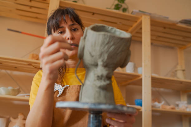 istock Young woman making pottery vase with clay in her workshop 1441418884