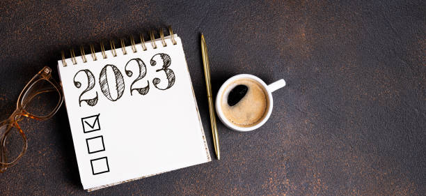 istock New year resolutions 2023 on desk. 2023 resolutions list with notebook, coffee cup on table. Goals, resolutions, plan, action, checklist concept. New Year 2023 background 1441419668