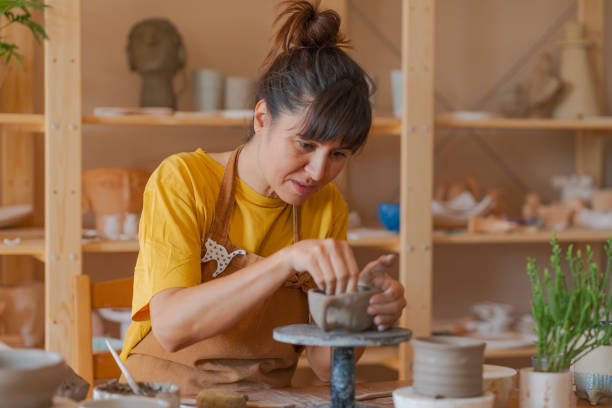 istock Potter woman making a cup in the workshop 1441420186
