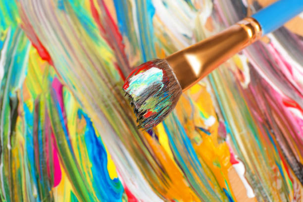 istock Abstract colorful acrylic paint and brush, closeup view 1441420394