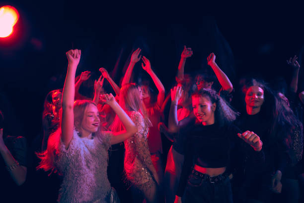 group of young people attending party, dancing, having fun over dark background in neon light. hippie generation - bar women silhouette child imagens e fotografias de stock