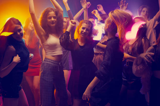 istock Group of young people attending party, dancing, having fun over dark background in neon light. Cheerful weekends 1441421103
