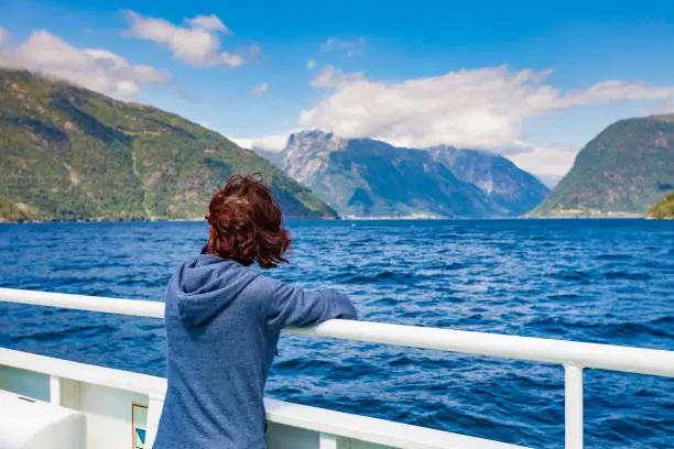 Tourism vacation and travel. Tourist woman on cruise ship enjoying fjord Sognefjord view in Norway, Scandinavia Europe.