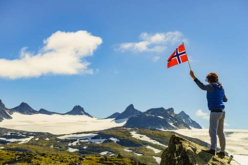 Female holding Swiss flag against mountain landscape