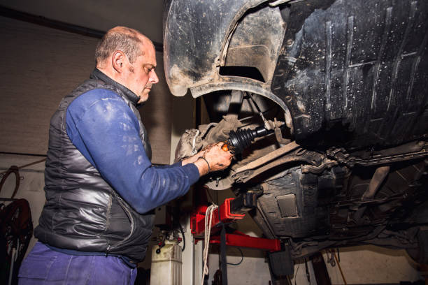 istock mechanic in workshop changing a drive shaft car 1441428862