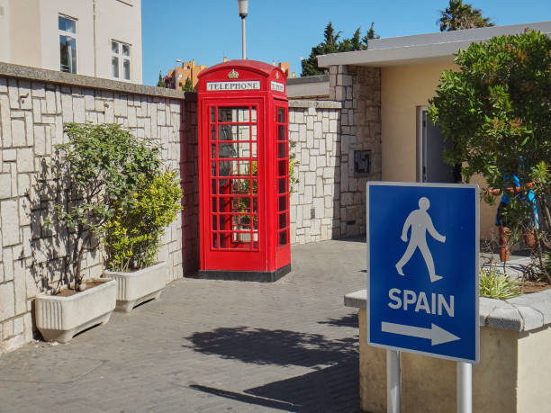 Gibraltar, United Kingdom - 06 08 2014: typical english telephone booth and blue and white pedestrian sign in the british sovereign territory in Spain