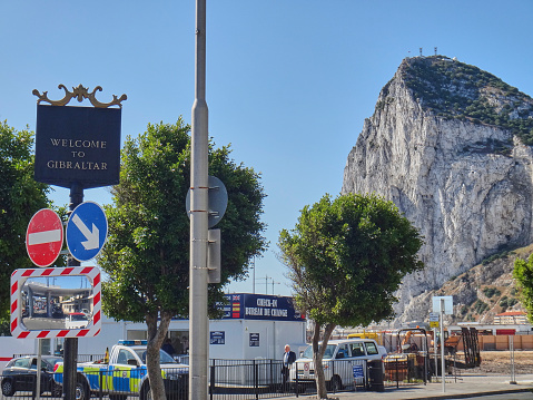 Gibraltar, United Kingdom - 06 08 2014: black and golden metal sign in the british sovereign territory in Spain saying welcome to Gibraltar with the rock of Gibraltar in the background