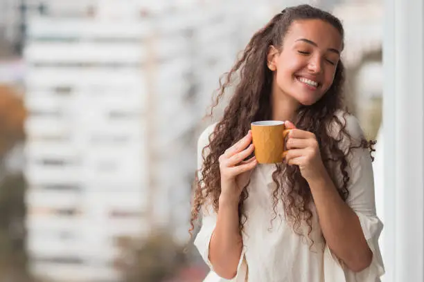 Photo of Woman with closed eyes enjoying a cup of coffee