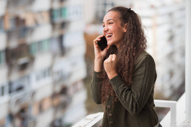 istock Woman having phone conversation and smiling in happiness 1441430626