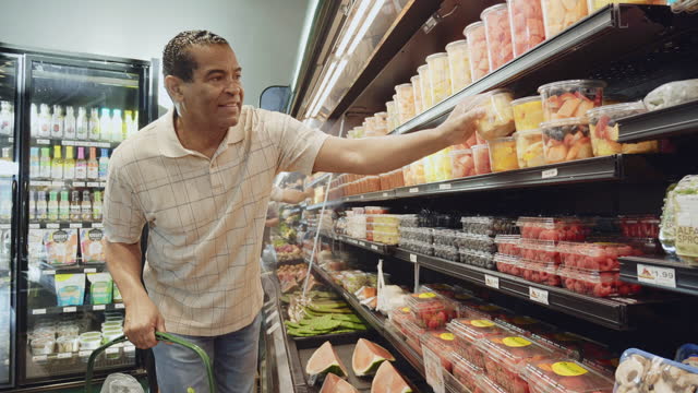 Man shops for fresh fruit in produce section of store